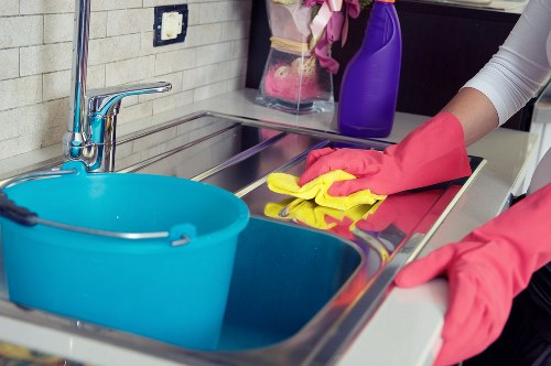 Professional cleaner resetting a Chelsea kitchen during an Airbnb turnover